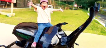 巨大カブトムシオブジェに乗った子ども